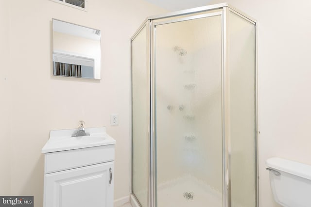 bathroom featuring vanity, toilet, and an enclosed shower