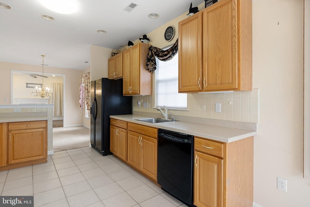 kitchen with a notable chandelier, backsplash, black appliances, sink, and decorative light fixtures