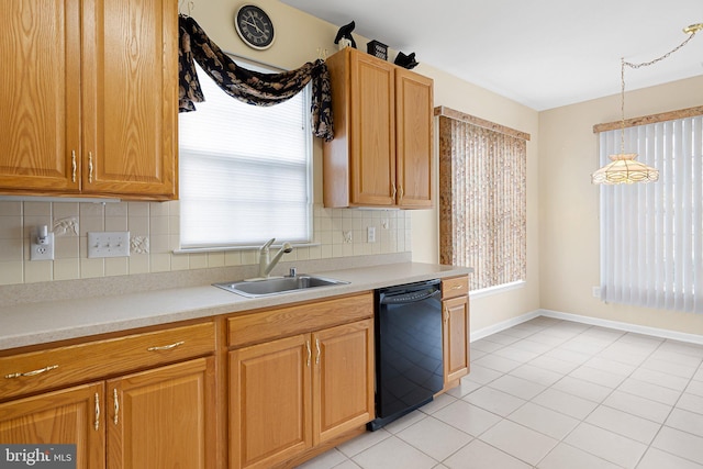 kitchen featuring tasteful backsplash, sink, light tile patterned floors, decorative light fixtures, and dishwasher