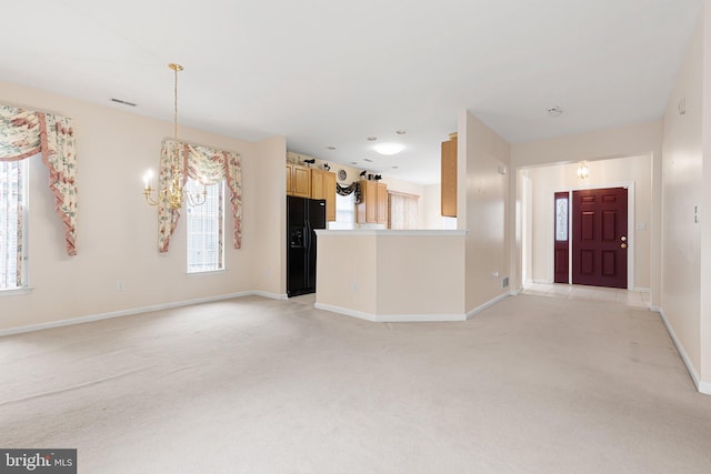 unfurnished living room with light carpet and a chandelier