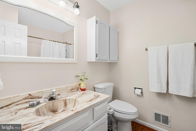 bathroom with vanity, wood-type flooring, toilet, and walk in shower