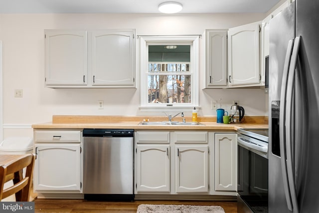 kitchen with white cabinetry, sink, stainless steel appliances, and dark hardwood / wood-style floors