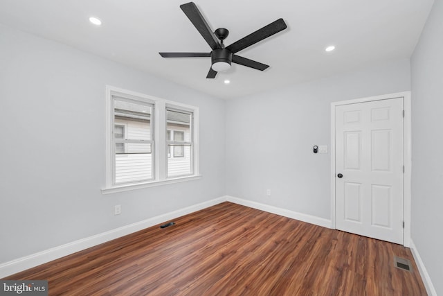 unfurnished room featuring ceiling fan and dark hardwood / wood-style flooring