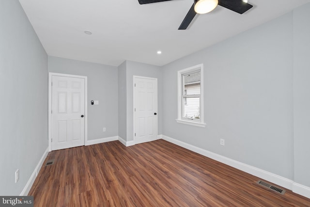 empty room with dark hardwood / wood-style floors and ceiling fan