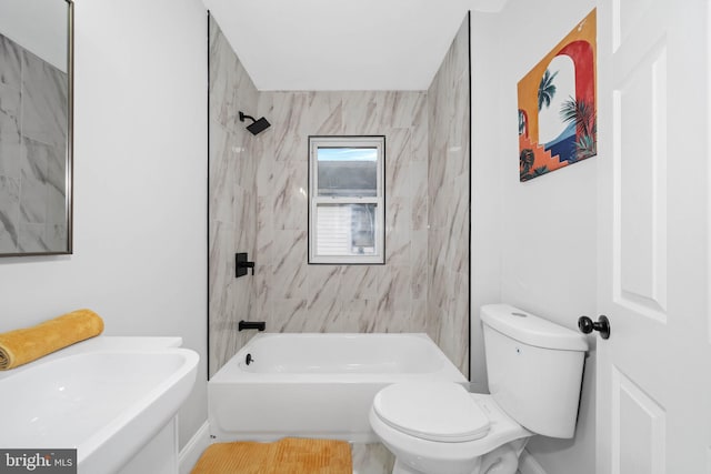 full bathroom with sink, tiled shower / bath combo, and toilet