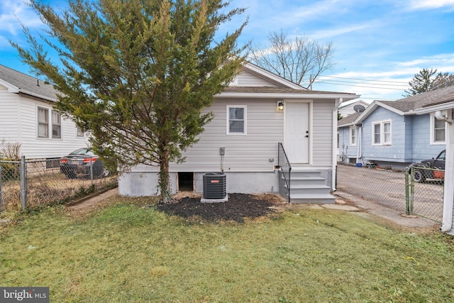 rear view of house featuring a yard and central AC