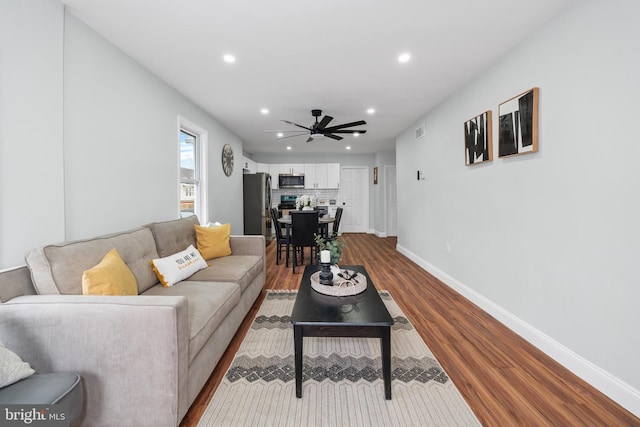 living room with ceiling fan and wood-type flooring