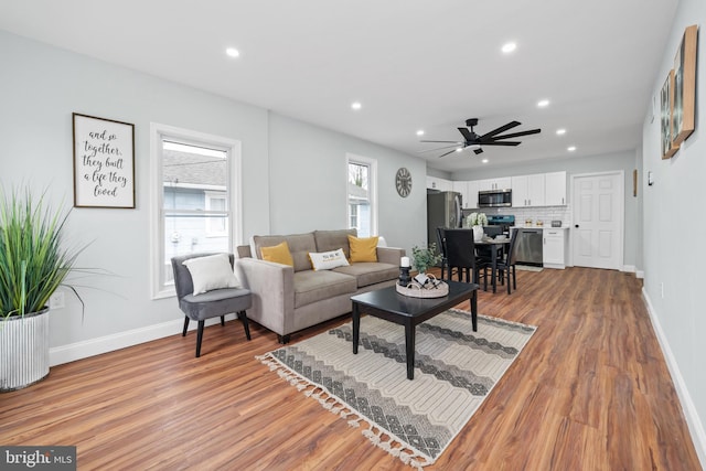 living room with ceiling fan and light hardwood / wood-style floors