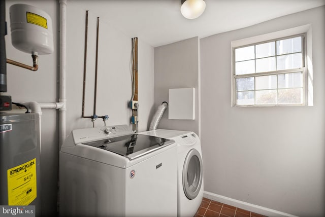 laundry area featuring water heater, dark tile patterned flooring, and washer and dryer