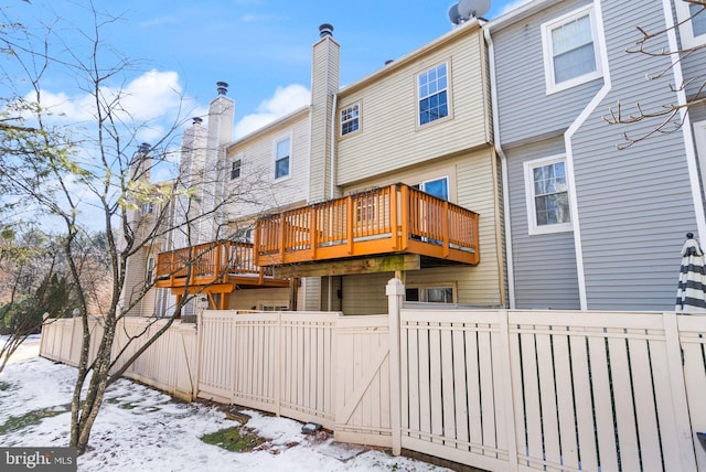 snow covered property with a deck