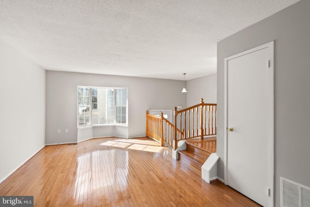 spare room featuring a textured ceiling and light wood-type flooring