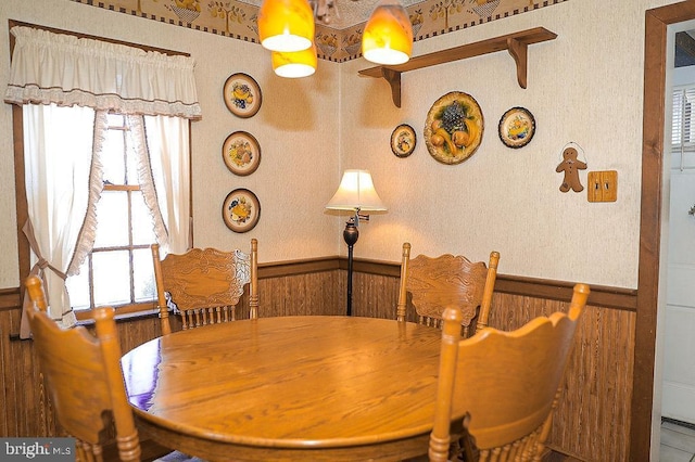 dining space featuring wood walls