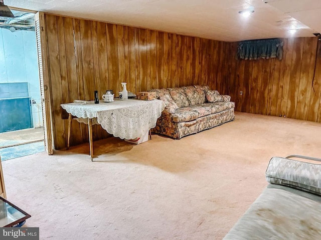 carpeted living room with wood walls