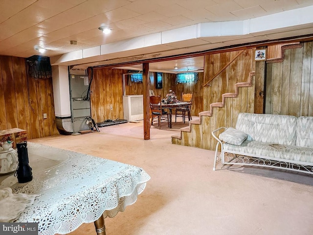 basement featuring carpet flooring and wood walls