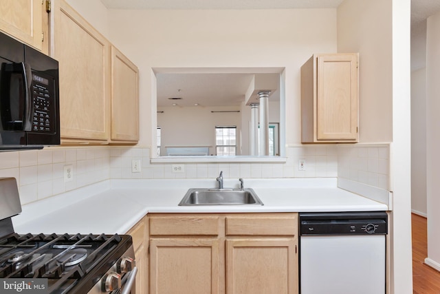 kitchen with gas range, sink, light brown cabinets, dishwasher, and hardwood / wood-style floors