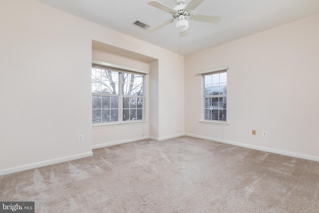 unfurnished room with light colored carpet and ceiling fan