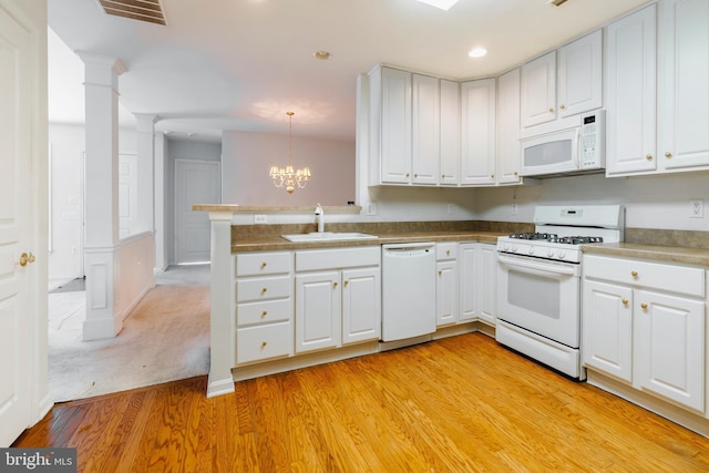 kitchen featuring white appliances, light hardwood / wood-style floors, white cabinetry, and hanging light fixtures