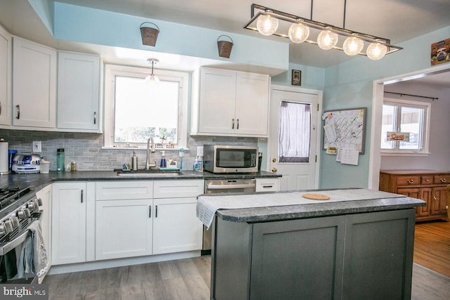 kitchen with a kitchen island, sink, white cabinetry, and stainless steel appliances