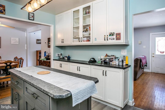 kitchen featuring gray cabinets, a center island, white cabinets, and dark wood-type flooring