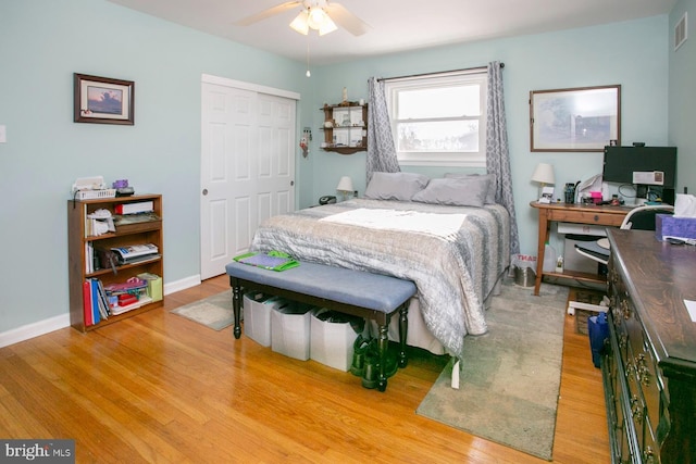 bedroom with hardwood / wood-style floors, ceiling fan, and a closet