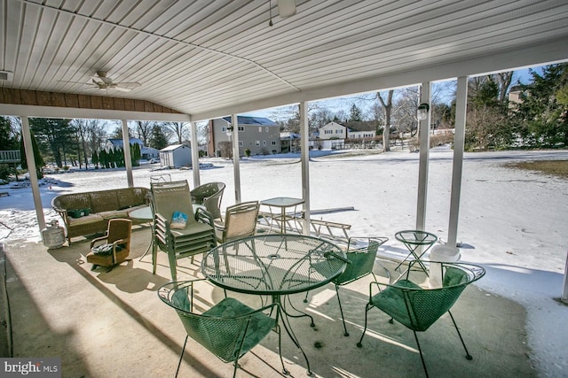 snow covered patio featuring ceiling fan