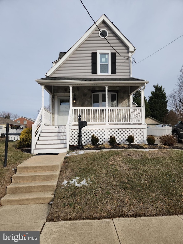 view of front of home with covered porch and a front yard