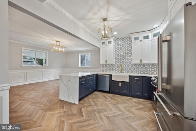 kitchen with pendant lighting, white cabinetry, blue cabinets, and appliances with stainless steel finishes