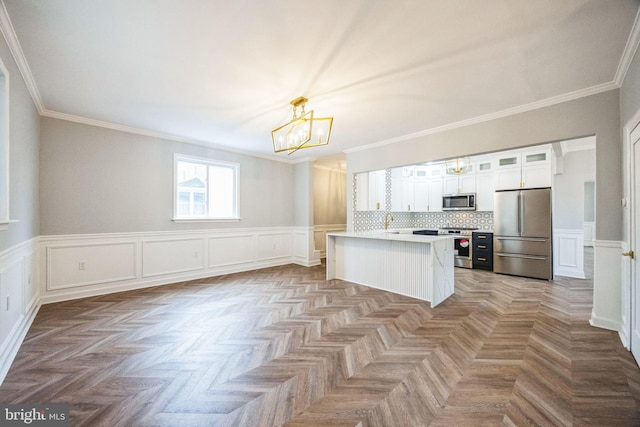 kitchen featuring pendant lighting, a chandelier, decorative backsplash, white cabinets, and appliances with stainless steel finishes