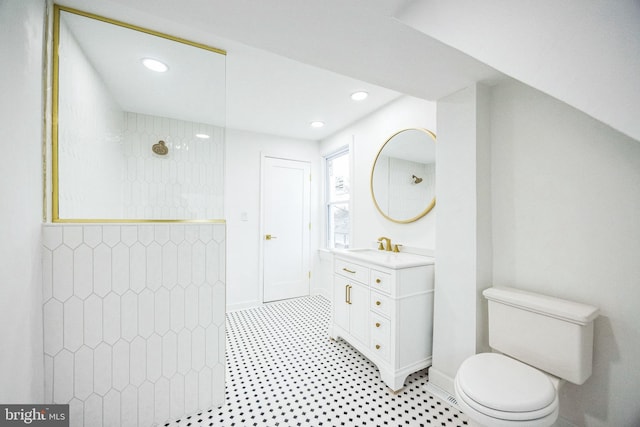 bathroom with vanity, toilet, and tiled shower