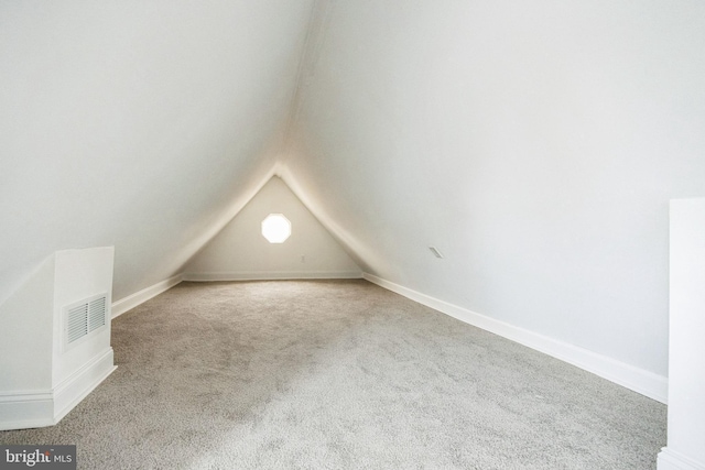 additional living space with carpet flooring and vaulted ceiling