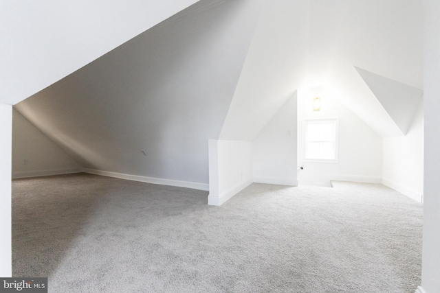 bonus room featuring light carpet and vaulted ceiling