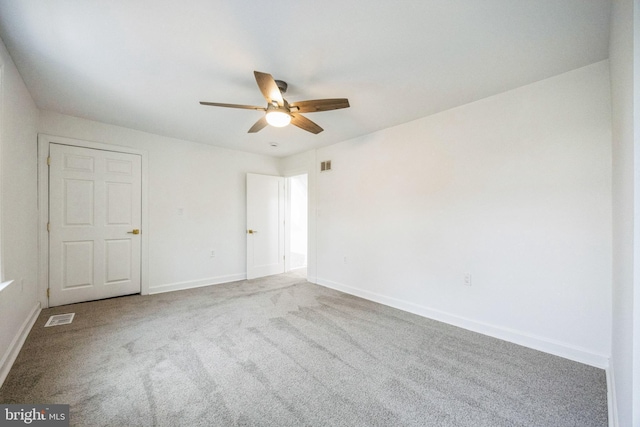 carpeted spare room with ceiling fan