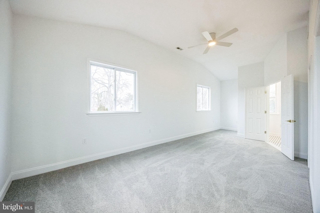 carpeted spare room featuring ceiling fan and lofted ceiling