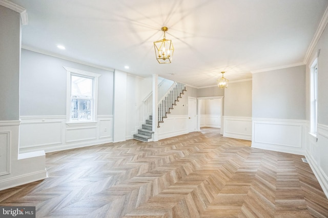 interior space featuring light parquet floors, an inviting chandelier, and crown molding