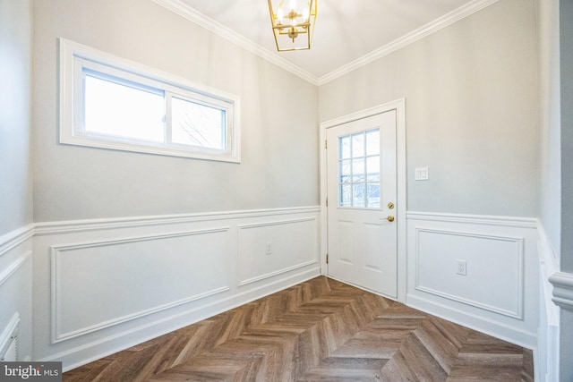 doorway to outside with an inviting chandelier, plenty of natural light, parquet floors, and crown molding