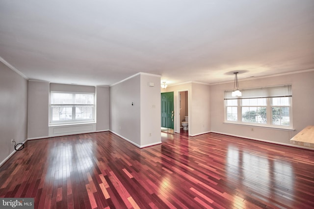 unfurnished living room with dark hardwood / wood-style floors, a healthy amount of sunlight, and crown molding