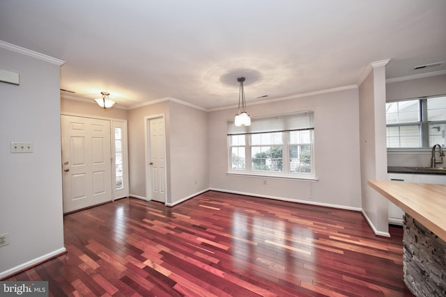 entrance foyer with ornamental molding, dark wood-type flooring, and sink