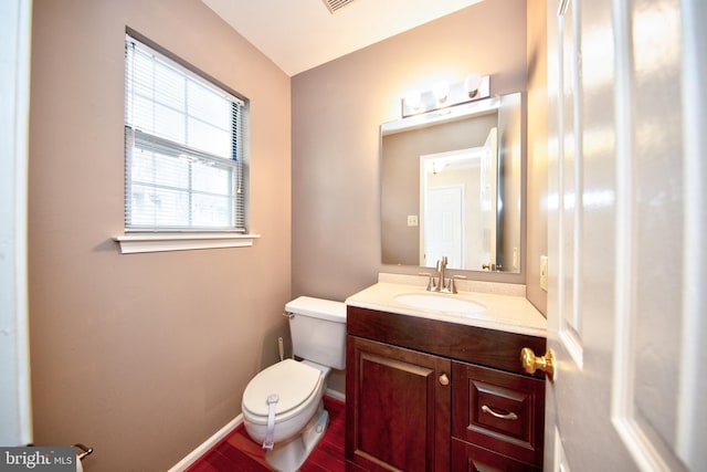 bathroom with hardwood / wood-style flooring, vanity, and toilet