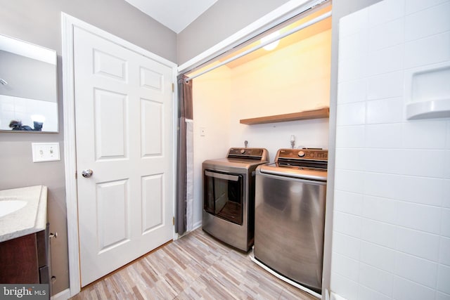 laundry room with washer and dryer and light hardwood / wood-style floors