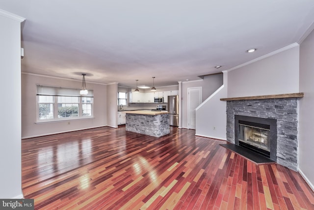 unfurnished living room with a fireplace, dark wood-type flooring, and crown molding