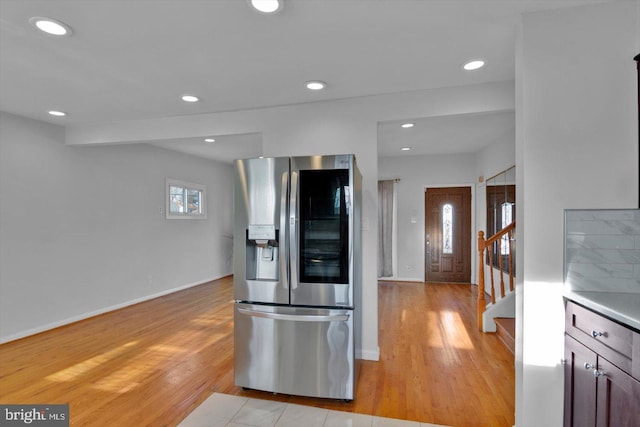 kitchen featuring light wood-type flooring, stainless steel refrigerator with ice dispenser, baseboards, and recessed lighting