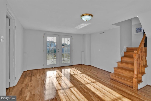 interior space featuring stairs, french doors, wood finished floors, and visible vents