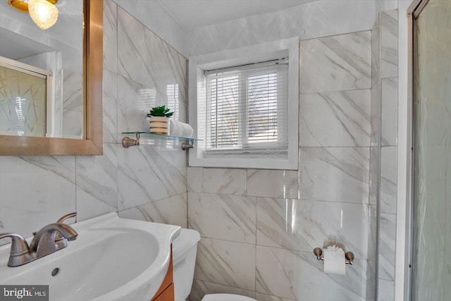 bathroom with tile walls, toilet, a shower stall, and vanity