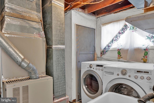 washroom featuring a sink, laundry area, and washer and dryer