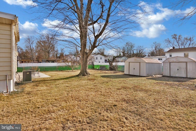 view of yard featuring a storage shed, fence, a patio, and an outdoor structure