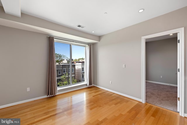 spare room with a wealth of natural light and light hardwood / wood-style flooring