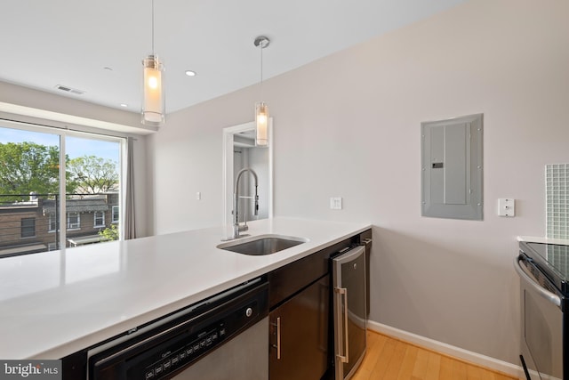 kitchen featuring sink, stainless steel dishwasher, electric panel, decorative light fixtures, and light wood-type flooring