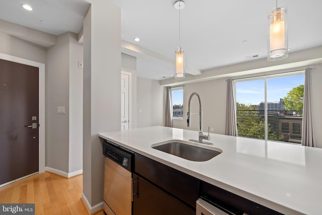 kitchen featuring plenty of natural light, dishwasher, decorative light fixtures, and sink