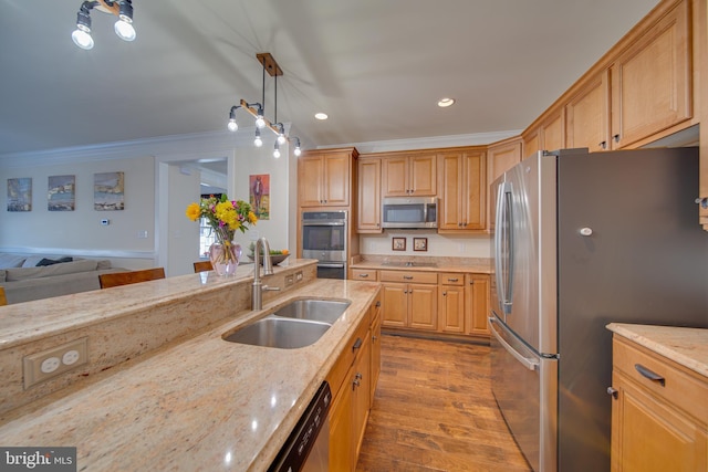 kitchen featuring sink, light stone counters, decorative light fixtures, appliances with stainless steel finishes, and ornamental molding