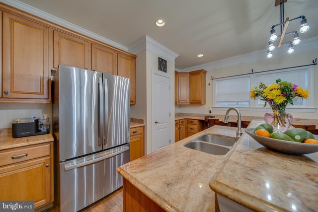 kitchen with sink, ornamental molding, decorative light fixtures, light hardwood / wood-style floors, and stainless steel refrigerator